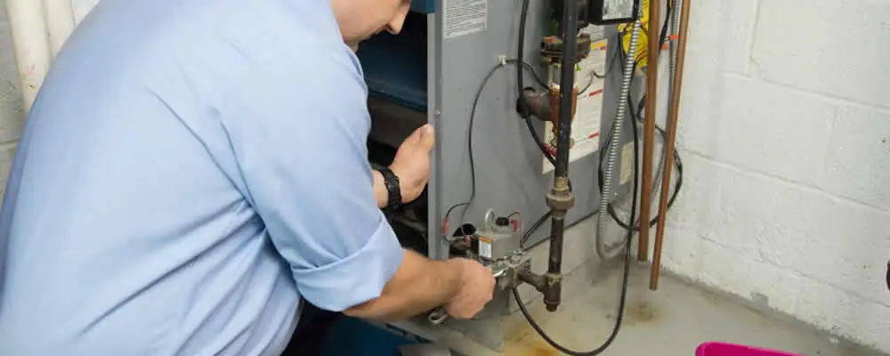 Furnace repair technician inspecting and servicing a home heating system in Warwick, RI