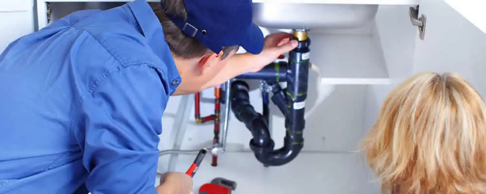 Plumber repairing under-sink drain pipes and fittings in Warwick, RI